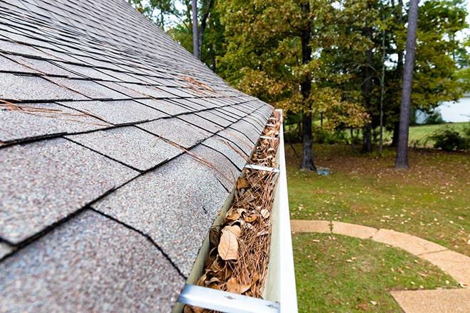 a professional gutter cleaner clearing debris