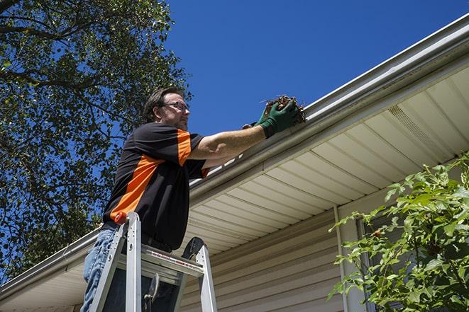 repairman sealing and reattaching a loose and sagging gutter in Val Verde, CA